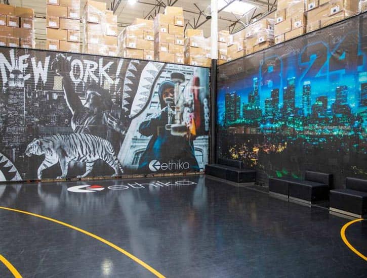 Full-color custom printed fence screens hanging in the FenceScreen warehouse