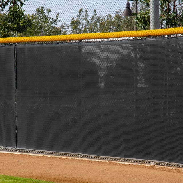 Vented windscreen on the outfield fence of a baseball field