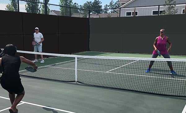 Sound-deafening fence screen besides pickleball court